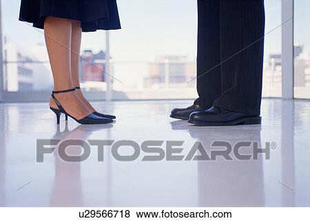 Stock Photo - Business people’s feet in office. Fotosearch
