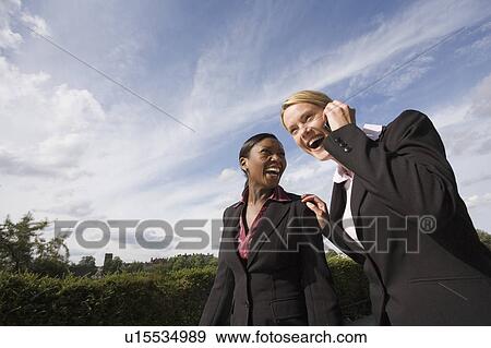 Stock Photo - Business women laughing outdoors. Fotosearch