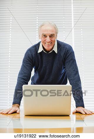Businessman at laptop in office View Large Photo Image Stock Image - Businessman at laptop in office. Fotosearch