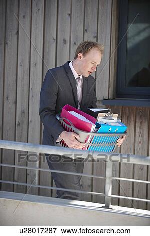 Stock Photo - Businessman carrying box of supplies. Fotosearch