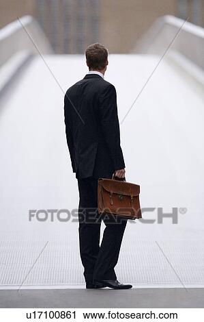 Businessman carrying briefcase outdoors View Large Photo Image Stock Image - Businessman carrying briefcase outdoors. Fotosearch