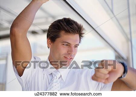Businessman checking his watch View Large Photo Image Stock Image - Businessman checking his watch. Fotosearch