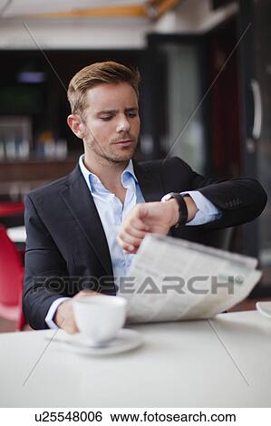 Businessman checking time at breakfast View Large Photo Image Stock Photograph - Businessman checking time at breakfast. Fotosearch