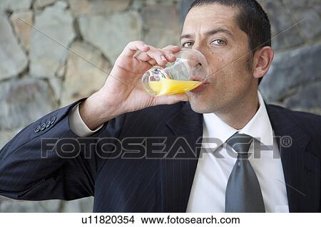 Picture - Businessman drinking orange juice. Fotosearch