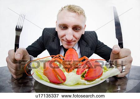 Stock Photo - Businessman eating plate of lobster. Fotosearch