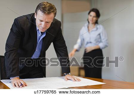 Stock Photography - Businessman examining blueprints. Fotosearch