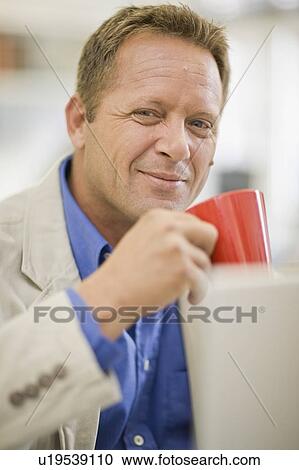 Stock Image - Businessman having cup of coffee. Fotosearch
