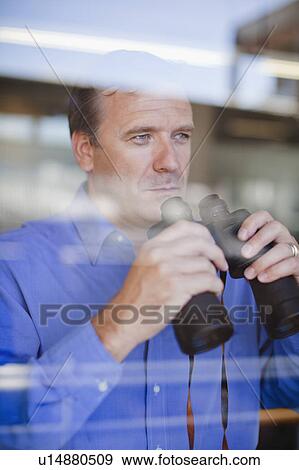Stock Photo - Businessman holding binoculars. Fotosearch