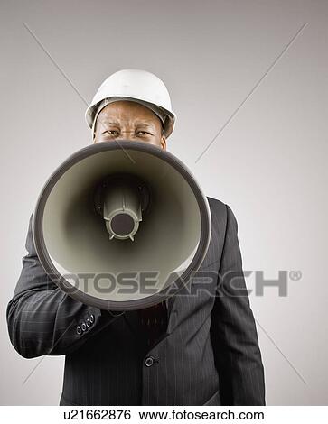 Businessman in hard hat using megaphone View Large Photo Image Stock Photograph - Businessman in hard hat using megaphone. Fotosearch