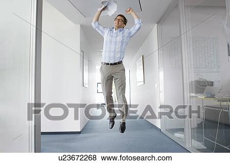 Stock Photo - Businessman jumping for joy in office. Fotosearch