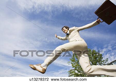 Stock Image - Businessman jumping for joy outdoors. Fotosearch