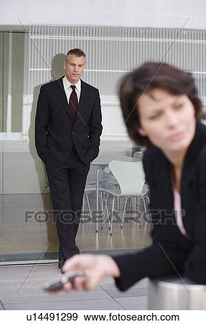 Stock Photo - Businessman leaning on glass wall. Fotosearch
