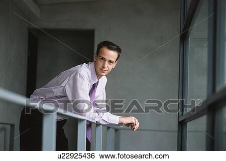 Stock Photograph - Businessman leaning on railing. Fotosearch