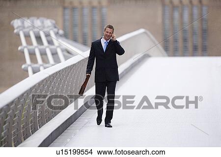 Businessman on cell phone outdoors View Large Photo Image Picture - Businessman on cell phone outdoors. Fotosearch