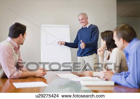 Picture - Businessman presenting graph in meeting. Fotosearch