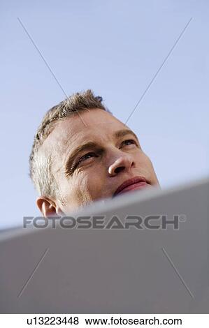 Stock Photo - Businessman reading papers outdoors. Fotosearch