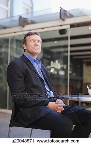 Stock Image - Businessman relaxing outside office. Fotosearch