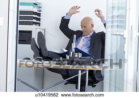 Businessman relaxing with feet on desk View Large Photo Image Stock Image - Businessman relaxing with feet on desk. Fotosearch