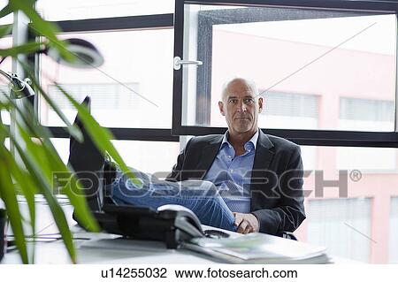 Businessman relaxing with feet on desk View Large Photo Image Stock Image - Businessman relaxing with feet on desk. Fotosearch