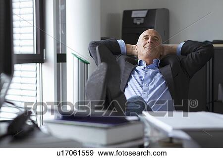 Businessman relaxing with feet on desk View Large Photo Image Stock Photo - Businessman relaxing with feet on desk. Fotosearch