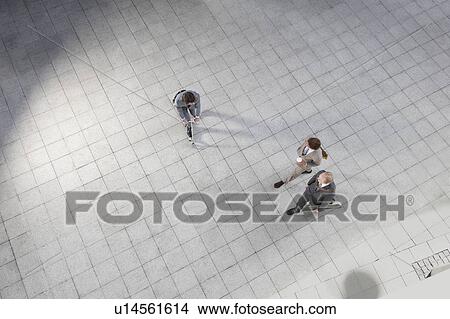 Businessman riding scooter in courtyard View Large Photo Image Picture - Businessman riding scooter in courtyard. Fotosearch