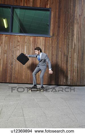 Businessman riding skateboard View Large Photo Image Picture - Businessman riding skateboard. Fotosearch