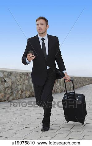 Stock Image - Businessman running with luggage. Fotosearch