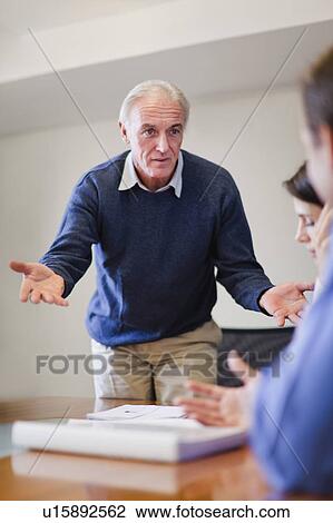 Businessman shrugging in meeting View Large Photo Image Stock Image - Businessman shrugging in meeting. Fotosearch