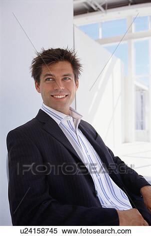 Stock Photography - Businessman sitting at desk. Fotosearch