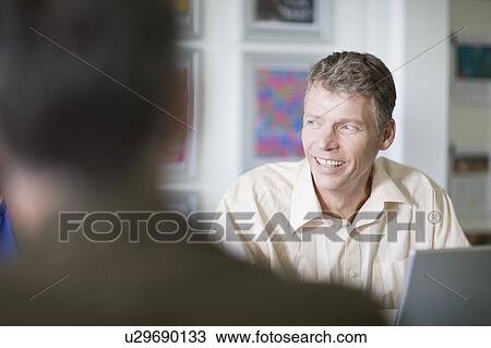 Businessman sitting in meeting View Large Photo Image Stock Image - Businessman sitting in meeting. Fotosearch
