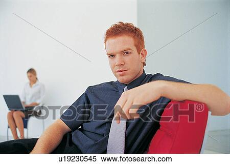 Businessman sitting on couch in office View Large Photo Image Stock Photography - Businessman sitting on couch in office. Fotosearch