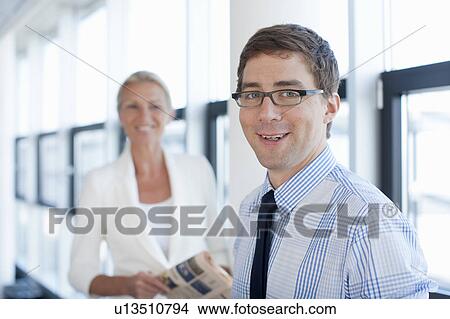 Businessman smiling in office View Large Photo Image Picture - Businessman smiling in office. Fotosearch