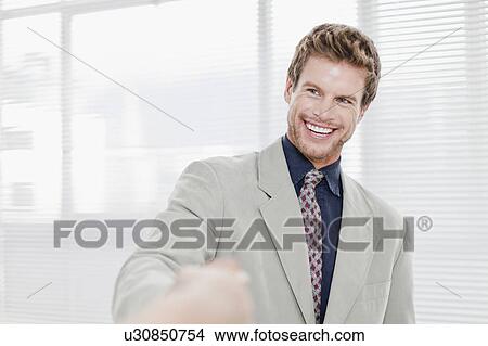 Picture - Businessman smiling in office. Fotosearch