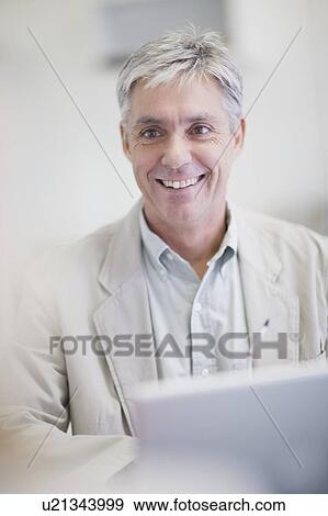 Stock Photo - Businessman smiling in office. Fotosearch