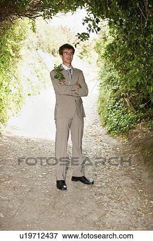 Businessman standing on rural road View Large Photo Image Stock Photo - Businessman standing on rural road. Fotosearch