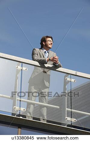 Businessman standing on walkway View Large Photo Image Stock Photography - Businessman standing on walkway. Fotosearch