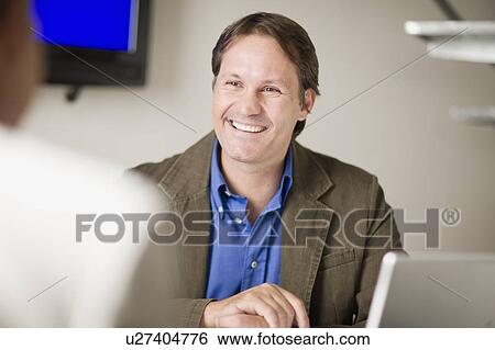 Businessman talking in office View Large Photo Image Stock Photograph - Businessman talking in office. Fotosearch