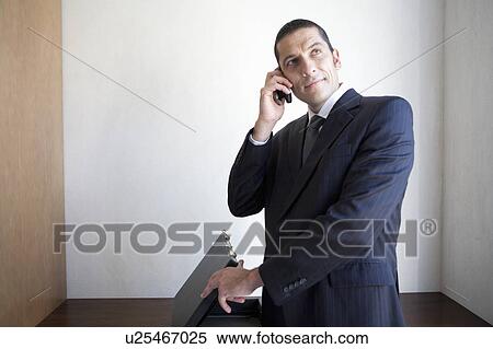 Stock Photography - Businessman talking on cell phone. Fotosearch