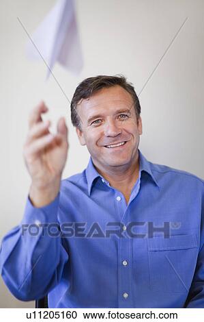 Businessman throwing paper airplane View Large Photo Image Stock Image - Businessman throwing paper airplane. Fotosearch