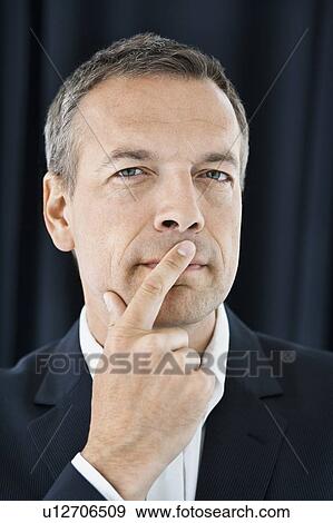 Businessman touching his lips View Large Photo Image Stock Photo - Businessman touching his lips. Fotosearch