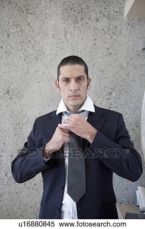 Stock Photography - Businessman tying his tie. Fotosearch