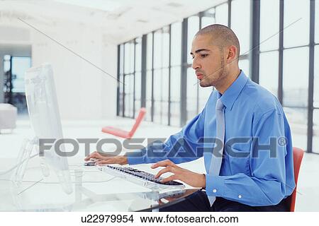 Picture - Businessman using computer in office. Fotosearch