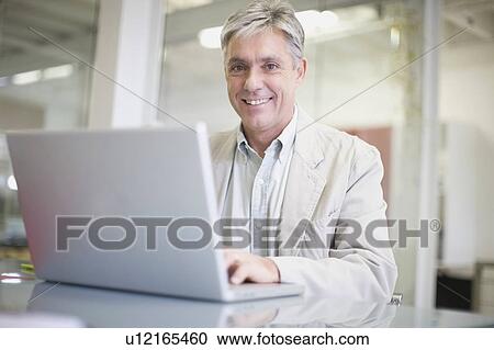 Businessman using laptop in office View Large Photo Image Stock Image - Businessman using laptop in office. Fotosearch
