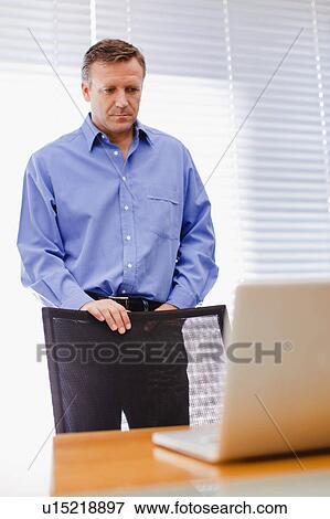 Businessman using laptop in office View Large Photo Image Stock Photo - Businessman using laptop in office. Fotosearch