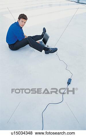 Stock Photo - Businessman using laptop on floor. Fotosearch