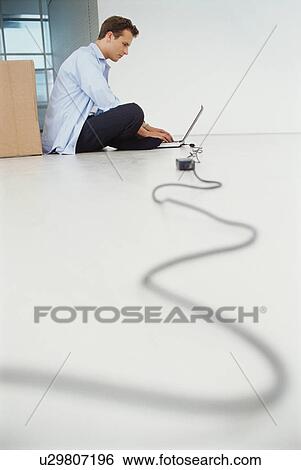 Stock Photograph - Businessman using laptop on floor. Fotosearch
