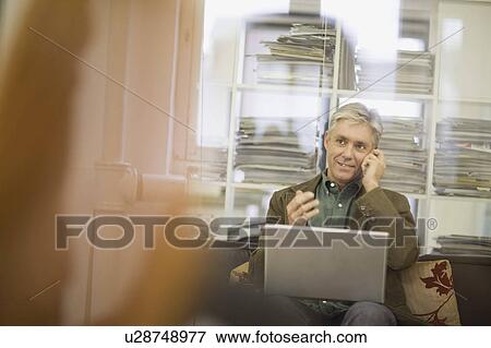 Businessman working on couch View Large Photo Image Stock Photo - Businessman working on couch. Fotosearch