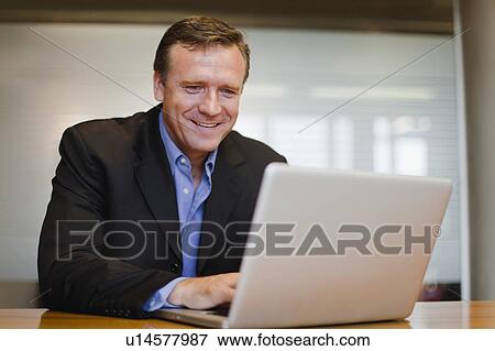 Businessman working on laptop View Large Photo Image Stock Photo - Businessman working on laptop. Fotosearch