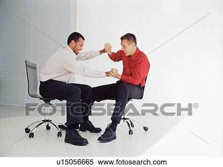 Businessmen playing in office chairs View Large Photo Image Stock Photography - Businessmen playing in office chairs. Fotosearch