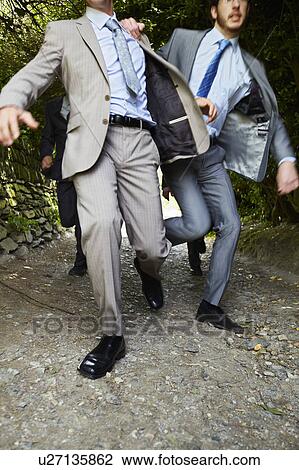 Stock Image - Businessmen racing on rural road. Fotosearch